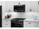 Close-up of the modern kitchen with stainless steel appliances and white cabinets at 208 Wade Creek Rd, Alpharetta, GA 30009
