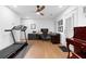 Spacious living area featuring hardwood floors, a ceiling fan, a treadmill, and a dedicated home office space at 208 Wade Creek Rd, Alpharetta, GA 30009