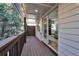 Side porch with brown wood flooring and white railings looking into the living room at 208 Wade Creek Rd, Alpharetta, GA 30009