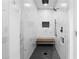 Modern shower with marble-look tile, black fixtures, corner bench, and black penny tile floor at 208 Wade Creek Rd, Alpharetta, GA 30009