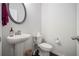 Bathroom features a pedestal sink, a round mirror and modern fixtures at 2517 Hedgeway Cir, Kennesaw, GA 30144