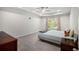 Cozy bedroom with plush carpeting, a tray ceiling, and natural light from a large window at 2517 Hedgeway Cir, Kennesaw, GA 30144