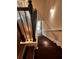 A staircase with dark wood steps, metal railing, and neutral wall paint leading to the front door at 2778 Wild Laurel Ct, Norcross, GA 30071
