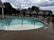 Community swimming pool with lounge chairs and umbrellas for residents to enjoy on a cloudy day at 2778 Wild Laurel Ct, Norcross, GA 30071