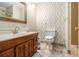 Bathroom featuring decorative wallpaper, a tile floor, and a wooden vanity at 5247 Yeager Rd, Douglasville, GA 30135