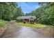 Inviting home featuring a long driveway and surrounded by lush greenery and mature trees at 5247 Yeager Rd, Douglasville, GA 30135
