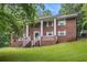 Traditional brick home featuring white columns and shutters, surrounded by lush greenery at 5247 Yeager Rd, Douglasville, GA 30135