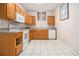 Kitchen featuring wooden cabinets, white appliances, and tile floors at 5247 Yeager Rd, Douglasville, GA 30135