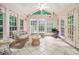 Bright sunroom with large windows, tile flooring, and comfortable wicker seating at 5247 Yeager Rd, Douglasville, GA 30135