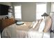 Comfortable bedroom featuring two windows, a television, dresser, and plush bed with decorative pillows at 710 Oxford Crest Ct, Lawrenceville, GA 30043