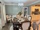 Elegant dining room featuring wainscoting, modern chandelier, and a view into the kitchen at 710 Oxford Crest Ct, Lawrenceville, GA 30043