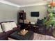 Cozy living room featuring a brown leather sofa and entertainment center with a TV at 710 Oxford Crest Ct, Lawrenceville, GA 30043