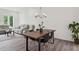 Bright dining area with wood table, four black chairs, modern chandelier, and adjacent living room at 1251 Chelsea Nw Cir, Atlanta, GA 30318