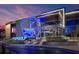 Exterior shot of Topgolf featuring bright neon signage, modern architecture, and landscaped entrance in the evening at 1251 Chelsea Nw Cir, Atlanta, GA 30318