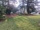 Spacious backyard with mature trees, lush lawn, and distant deck at 2775 Emerald Springs Dr, Lawrenceville, GA 30045