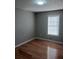 This bedroom features hardwood floors, a window for natural light, and freshly painted walls at 2775 Emerald Springs Dr, Lawrenceville, GA 30045