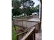 View of the wooden deck with a classic wooden railing, stairs and mature trees around the property at 2775 Emerald Springs Dr, Lawrenceville, GA 30045