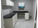The laundry room has a stainless steel sink, white cabinets, black countertop and white marble tile floors at 2775 Emerald Springs Dr, Lawrenceville, GA 30045