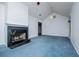 Bright living room features vaulted ceiling, fireplace, and blue carpeting at 6328 Wellington Ct, Douglasville, GA 30134