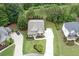 Aerial shot of a lovely home with a well-manicured lawn and a long driveway in a lush setting at 7070 Concord Mountain Trl, Cumming, GA 30028