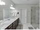 Bright bathroom with double sinks, large mirror, and glass-enclosed shower at 7070 Concord Mountain Trl, Cumming, GA 30028