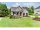 Beautifully landscaped front yard with lush green lawn surrounding a charming brick and siding home at 7070 Concord Mountain Trl, Cumming, GA 30028