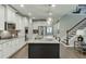 Kitchen with center island, undermount sink, stainless appliances, and view to adjacent stairwell at 7070 Concord Mountain Trl, Cumming, GA 30028