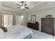 Spacious main bedroom featuring a ceiling fan, tray ceiling, and ensuite bathroom at 7070 Concord Mountain Trl, Cumming, GA 30028
