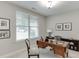 Comfortable home office with wooden desk, chair, and natural light from a large window with blinds at 7070 Concord Mountain Trl, Cumming, GA 30028