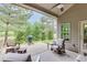Relaxing covered patio features ceiling fan, comfortable seating, and a grill for outdoor entertaining at 7070 Concord Mountain Trl, Cumming, GA 30028