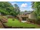Spacious, green backyard with deck, stairs, storage shed, and mature trees offering privacy at 735 Waterbrook Ter, Roswell, GA 30076