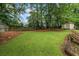 Green backyard with a wooden fence and storage shed, perfect for outdoor activities at 735 Waterbrook Ter, Roswell, GA 30076