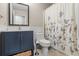 Well-maintained bathroom with navy vanity, white marble top, framed mirror and decorative shower curtain at 735 Waterbrook Ter, Roswell, GA 30076