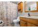Well lit bathroom featuring a shower/tub combo with a decorative shower curtain and wooden vanity at 735 Waterbrook Ter, Roswell, GA 30076