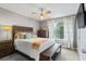 Cozy bedroom featuring a comfortable queen-size bed, a ceiling fan, and a sunlit window with curtains at 735 Waterbrook Ter, Roswell, GA 30076