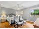 Bedroom featuring hardwood floors, a ceiling fan, and comfortable seating area with natural light from the window at 735 Waterbrook Ter, Roswell, GA 30076