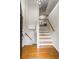 Bright foyer featuring hardwood floors, stairs with wood handrail, and access to the kitchen at 735 Waterbrook Ter, Roswell, GA 30076