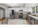 Bright kitchen with stainless steel appliances, granite countertops, and modern finishes at 735 Waterbrook Ter, Roswell, GA 30076