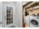 A tidy laundry room with a washing machine, dryer, and wire shelving for storage solutions at 735 Waterbrook Ter, Roswell, GA 30076