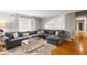 Bright living room featuring a large gray sectional sofa, hardwood floors and stylish decor at 735 Waterbrook Ter, Roswell, GA 30076