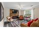 Comfortable living room with fireplace, large window, ceiling fan, and modern flooring at 735 Waterbrook Ter, Roswell, GA 30076