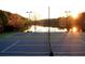 Community tennis courts with a view of the lake at sunset at 735 Waterbrook Ter, Roswell, GA 30076