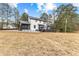 An expansive lawn complements the white two-story home with a dark deck, enhancing outdoor living and charm at 260 Sandy Lake Cir, Fayetteville, GA 30214