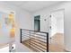 Bright hallway with wood floors, modern railings, and stylish pendant lighting at 260 Sandy Lake Cir, Fayetteville, GA 30214