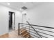 Hallway with hardwood floors, modern railings, and bathroom with black tile accents at 260 Sandy Lake Cir, Fayetteville, GA 30214
