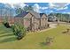 Spacious home with a large, well-maintained lawn and a side view of the brick exterior at 4580 Cloister Cir, Hampton, GA 30228