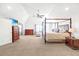 Spacious primary bedroom with vaulted ceiling, complemented by a decorative four-poster bed and furnishings at 4580 Cloister Cir, Hampton, GA 30228