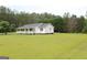 Exterior view of a home with a well maintained lawn and long front porch at 124 Wynn Rd, Mcdonough, GA 30252