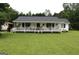 Charming home featuring a long porch, lush lawn, and mature trees at 124 Wynn Rd, Mcdonough, GA 30252