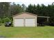 A two-car garage with additional covered storage, sitting on a lush green lawn at 124 Wynn Rd, Mcdonough, GA 30252